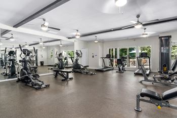 The fitness center boasts natural light, ceiling fans and a variety of equipment.
